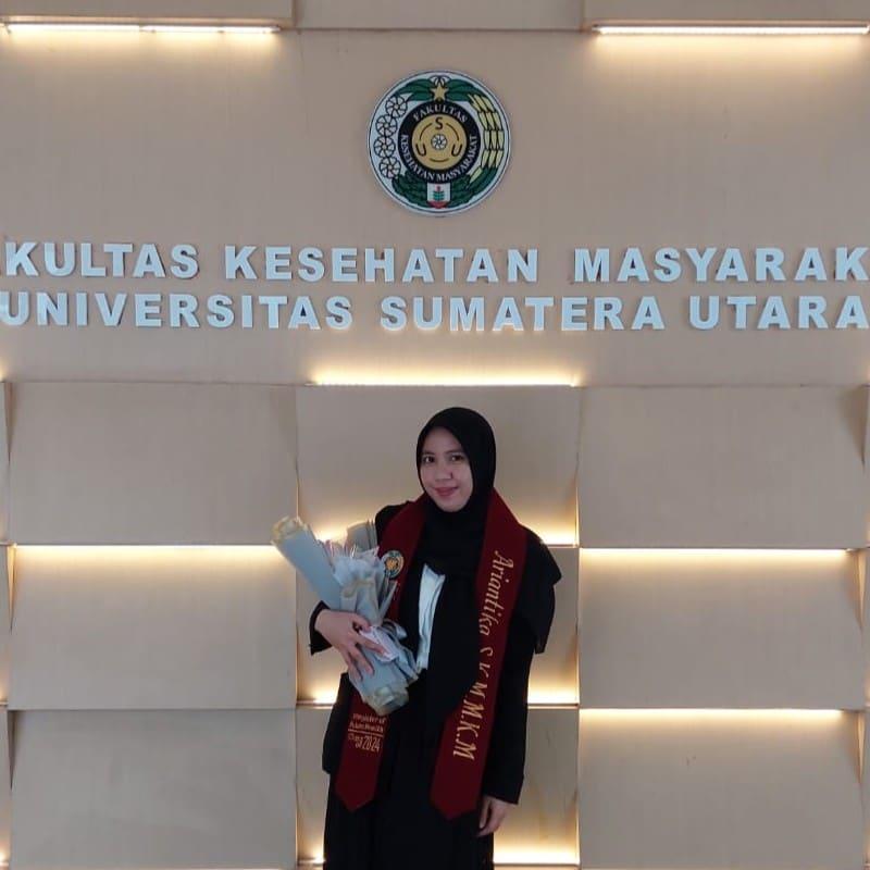Ariantika wearing a maroon graduation sash labeled Master of Public Health.